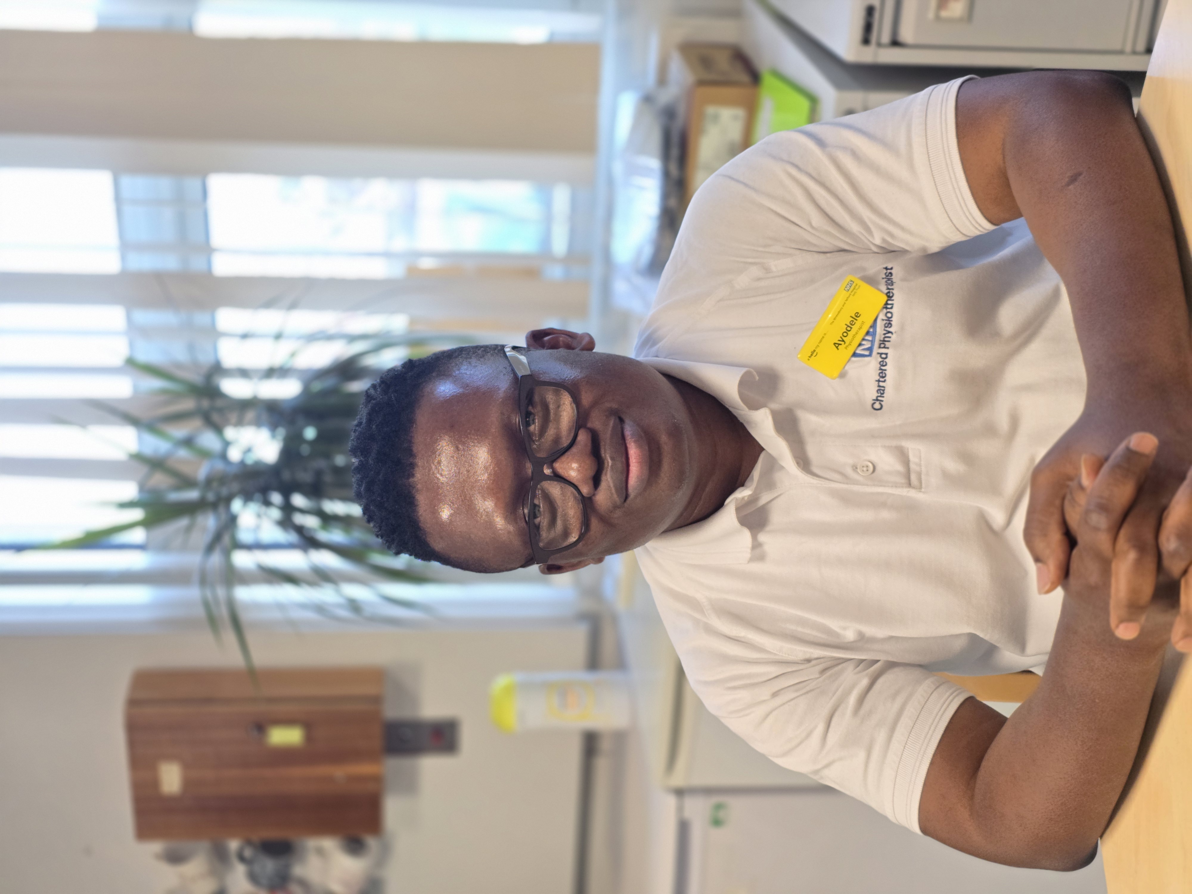 Man wearing glasses and a physiotherapist t-shirt