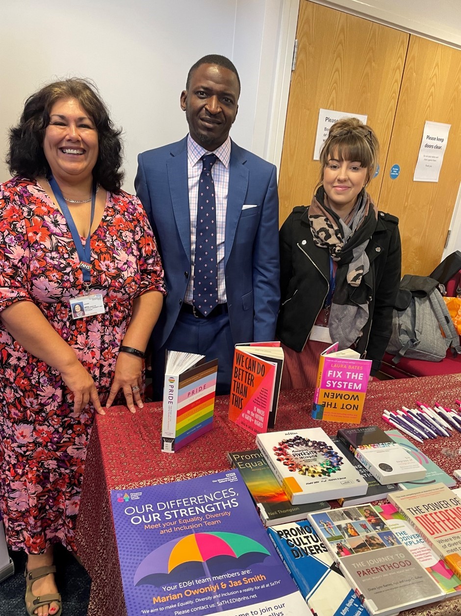 Group of diverse people standing by a display table